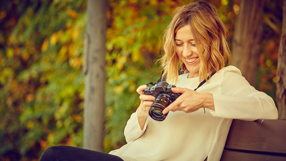 smiling photographer looking at camera on bench