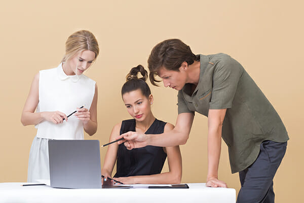 male and female giving feedback around laptop Feedback