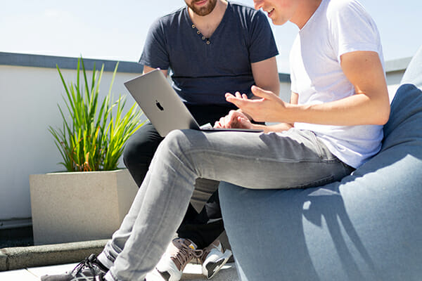 two males talking over a laptop